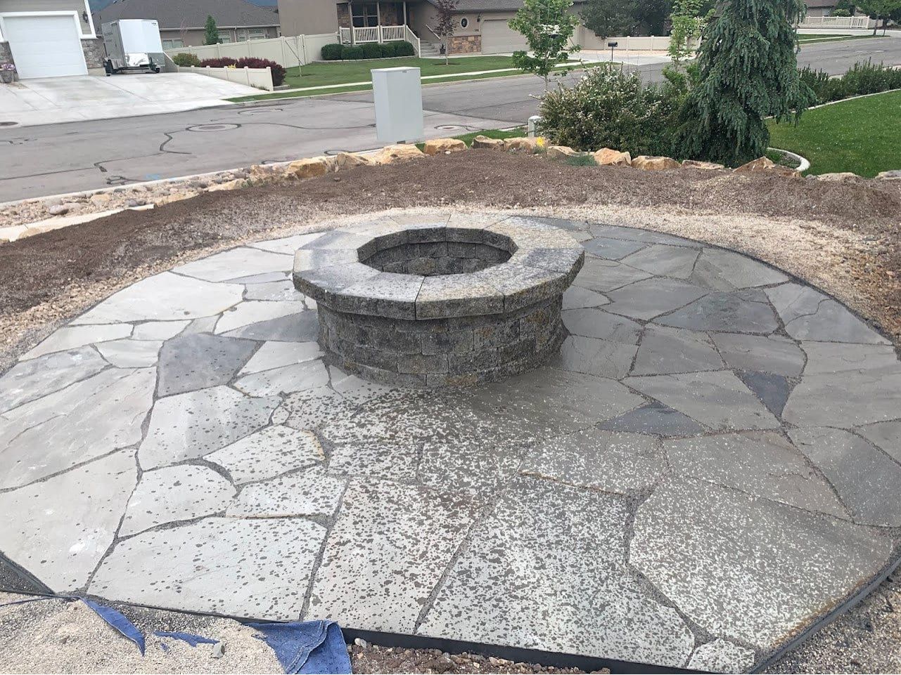 Round flagstone patio with a block fire pit in the center